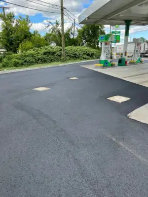 Resurfaced asphalt around the dispenser islands and access covers.