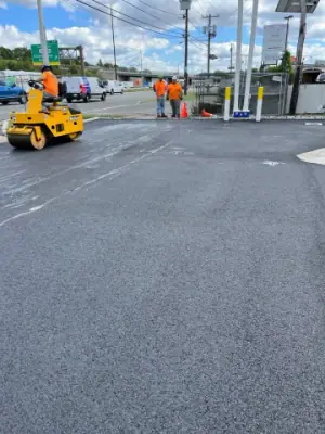 Compaction equipment and crew on the asphalt forecourt.