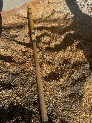 A pipe run exposed along the base of the excavation.