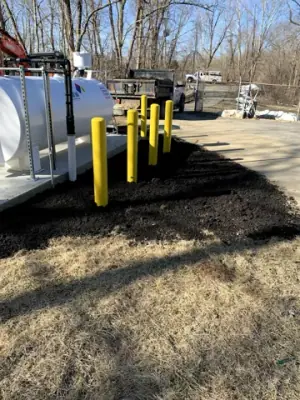 Installed aboveground tank and yellow protective bollards.