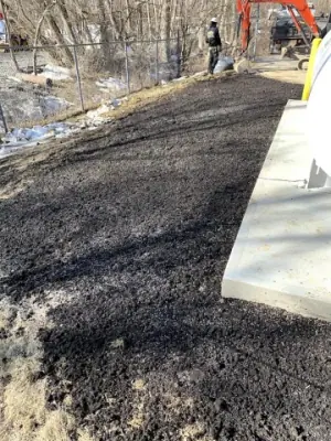 Restored ground and paved edge beside the tank installation.