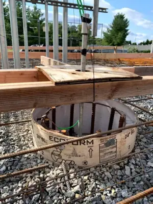 Open containment chamber and conduit connections below the concrete formwork.