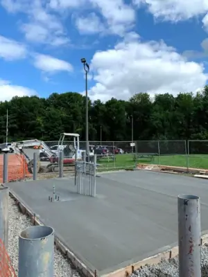Newly placed concrete pad surrounding the pipe risers.