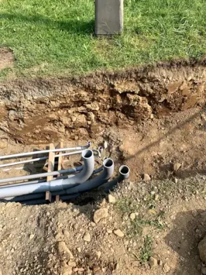 Parallel conduits routed along the open utility trench.