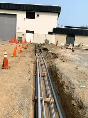 Parallel conduits routed along the open utility trench.