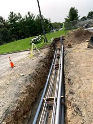 Parallel conduits routed along the open utility trench.