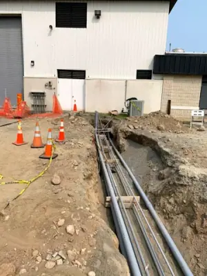 Parallel conduits routed along the open utility trench.