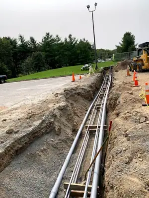 Parallel conduits routed along the open utility trench.