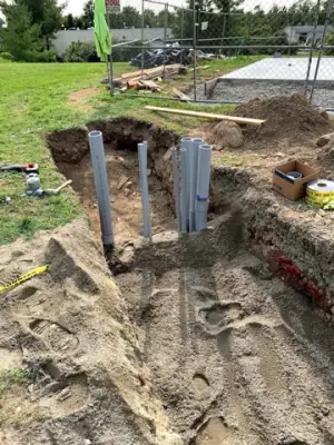 Underground utility runs and risers exposed before backfilling.