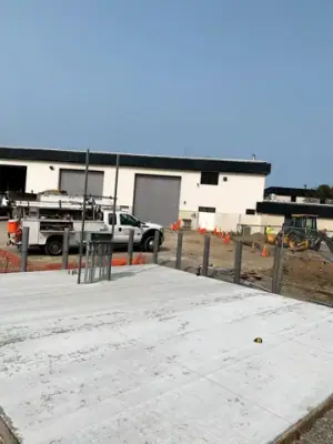 Finished concrete foundation with projecting pipe risers.