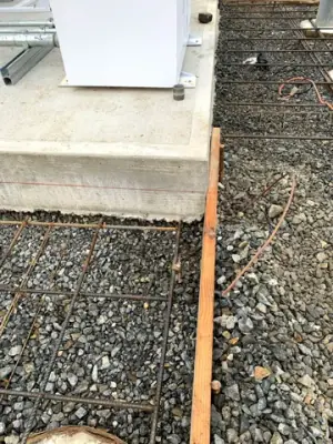 Protective posts and reinforced concrete forms alongside the installed tanks.