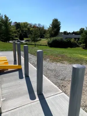 Yellow bollards beside the tank foundation and surrounding ground.