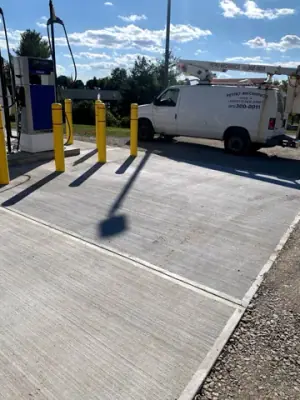 Installed fueling equipment and bollards on the concrete apron.