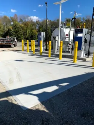 Installed fueling equipment and bollards on the concrete apron.