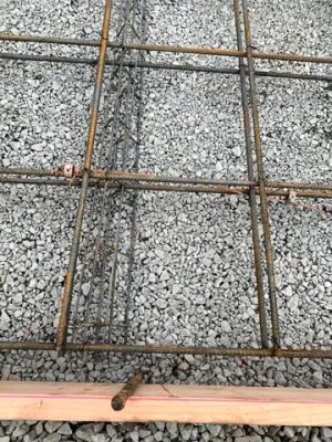 Reinforced concrete formwork over a compacted aggregate base.