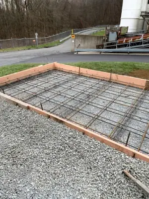 Reinforced concrete formwork over a compacted aggregate base.