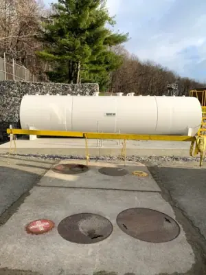 Side view of the aboveground tank installed beside the retaining wall.
