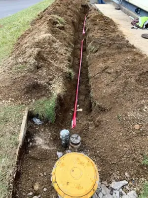 Trench and marked underground services beside the facility.