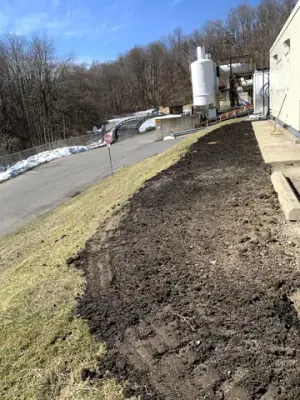 Graded ground alongside the concrete edge after utility work.
