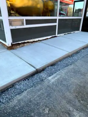 New concrete walkway along the storefront windows.