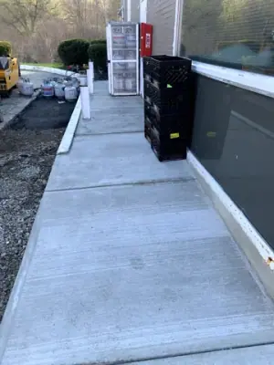 Long concrete walkway beside the building and display equipment.