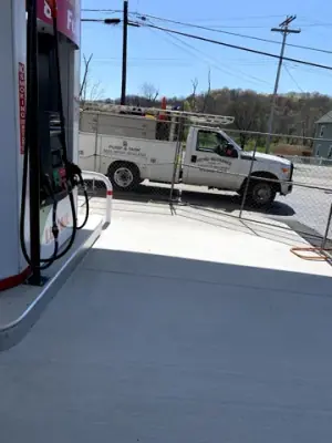 Finished concrete and a service vehicle beside a dispenser.