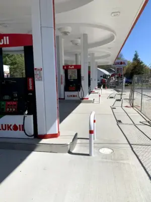 Finished fueling lanes, dispensers, and protective rails beneath the canopy.