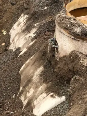 Side of an existing buried tank uncovered during excavation.