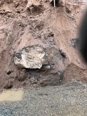 Rock and soil exposed in the wall of the excavation.