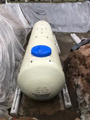 New underground tank positioned inside the lined excavation.