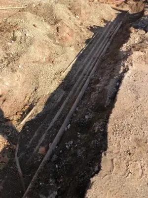 Parallel lines exposed beneath the ground surface.
