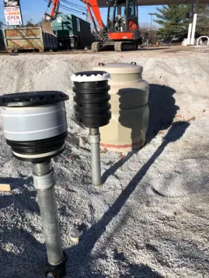 Group of tank risers and containment fittings in aggregate bedding.