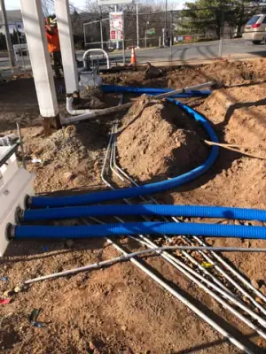 Blue piping and metal conduits near a canopy-column base.