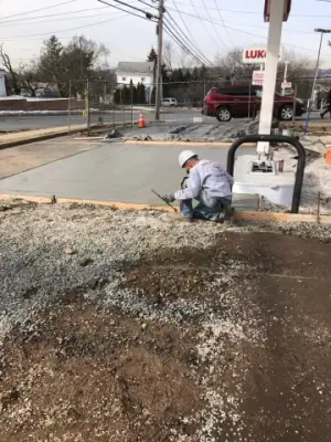Crew working on concrete beside a canopy column.