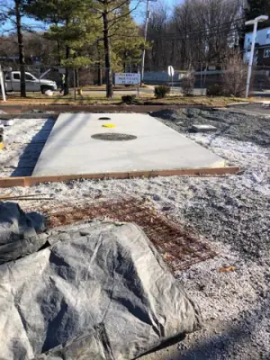 New tank-area concrete slab with access openings.