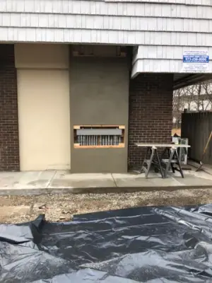Building exterior wall and recessed opening above the walkway.