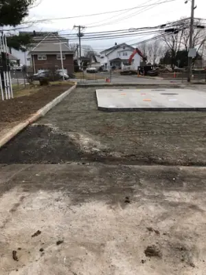 Graded aggregate and concrete tank pad across the forecourt.