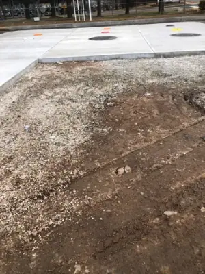 Graded ground connecting the existing pavement to the concrete pad.