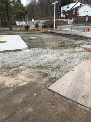 Graded ground connecting the existing pavement to the concrete pad.