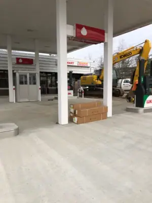 Canopy columns and installed dispensing equipment beside a work vehicle.
