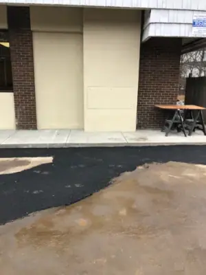 Asphalt patch beside the building and new walkway.