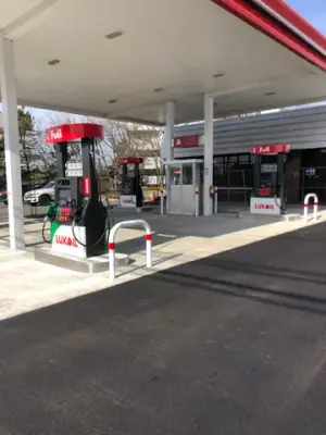 Installed dispensers and protective rails on the concrete fueling apron.