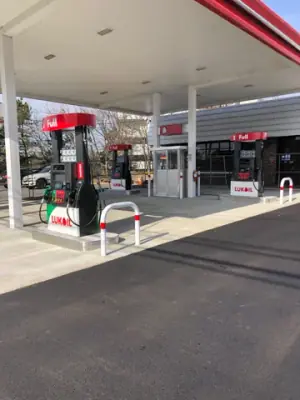 Installed dispensers and protective rails on the concrete fueling apron.